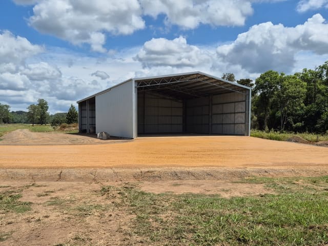 Compacted gravel shed pad and hardstand in front of a large new steel farm shed on a rural block